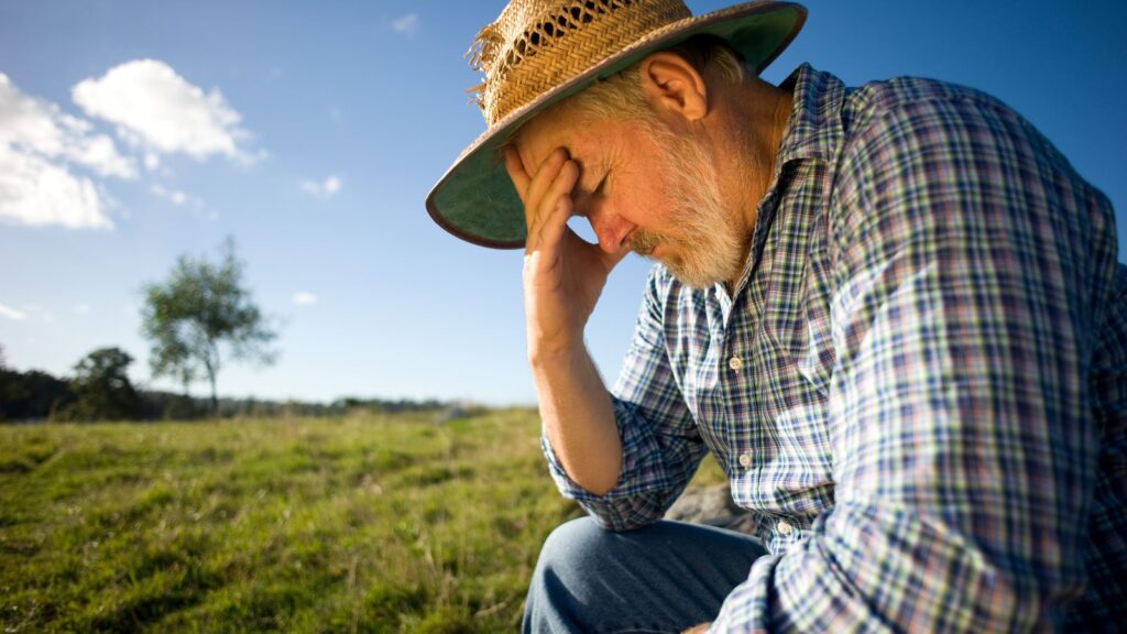 An entrepreneur thinking about his business challenges with his hand on his head