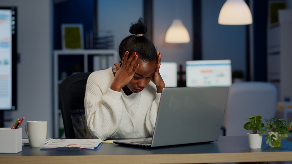 Businesswoman trying to work while dealing with workplace trauma