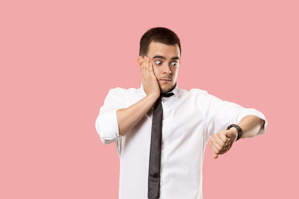 A young business owner checking his time