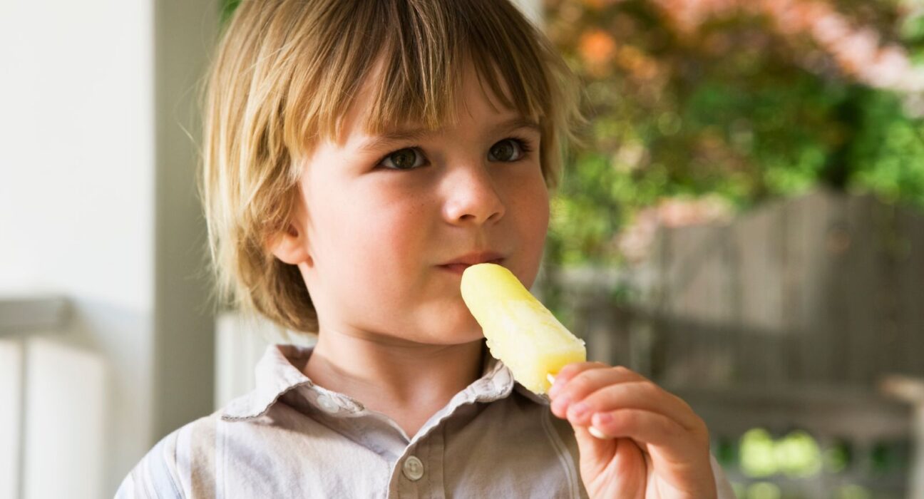 A young boy eating a Jonny pops