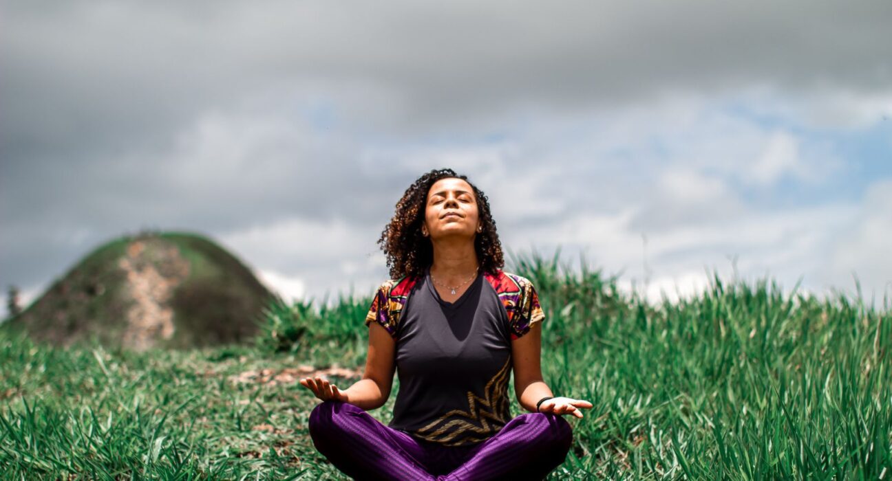 Young woman meditating outdoors in the fields