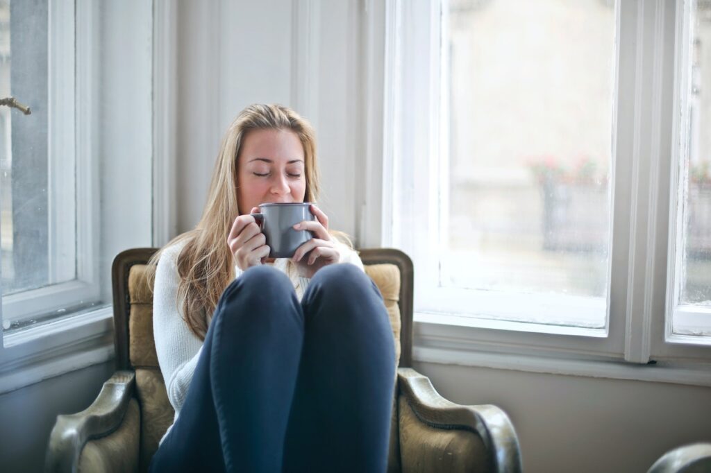 Woman Sitting On a Chair Holding Gray Ceramic Mug