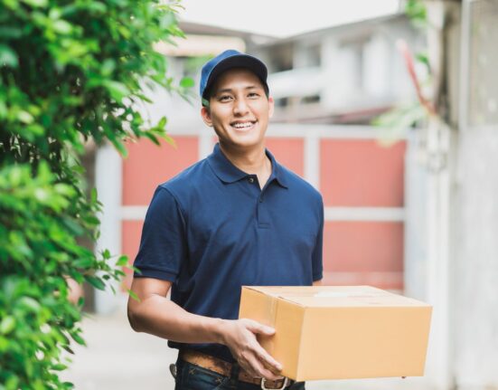 Young delivery man holding a package for delivery
